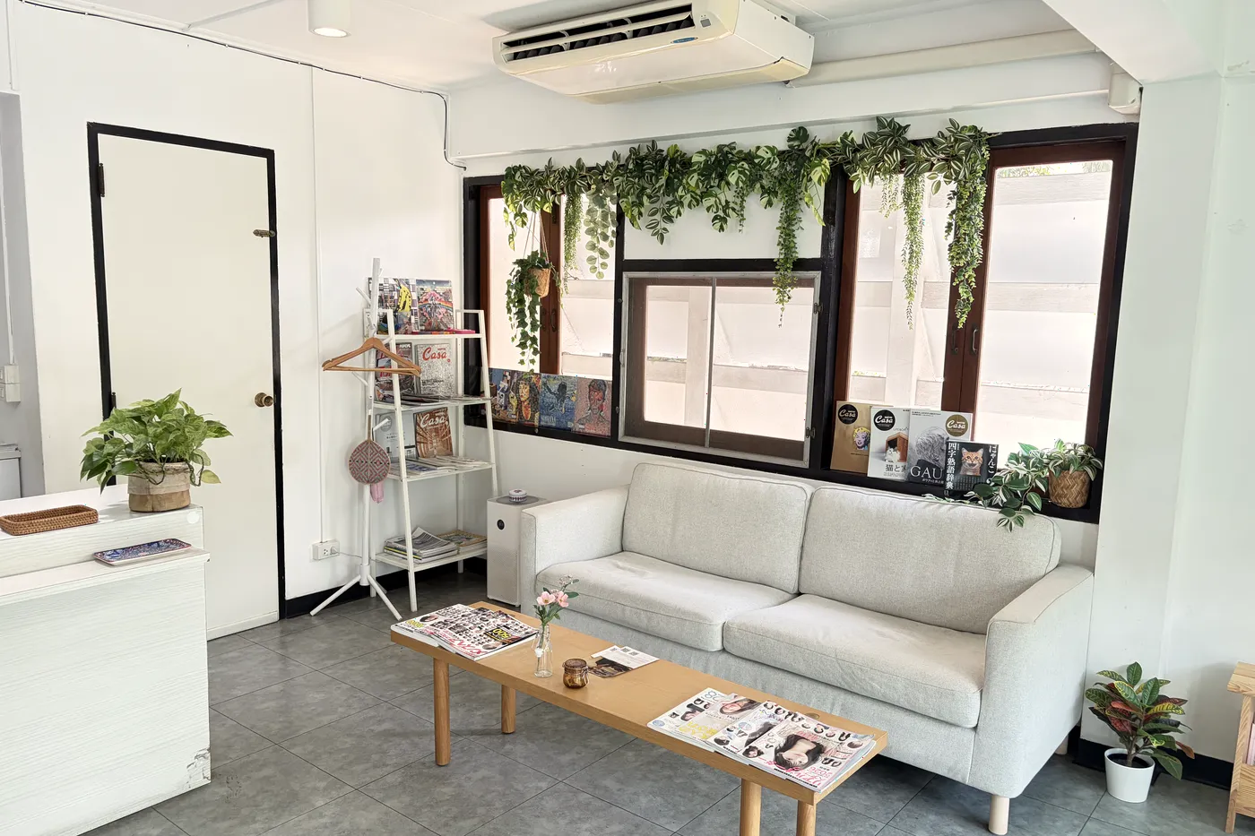BALCONY トンロー店の待合。窓辺のグリーンと白いソファ